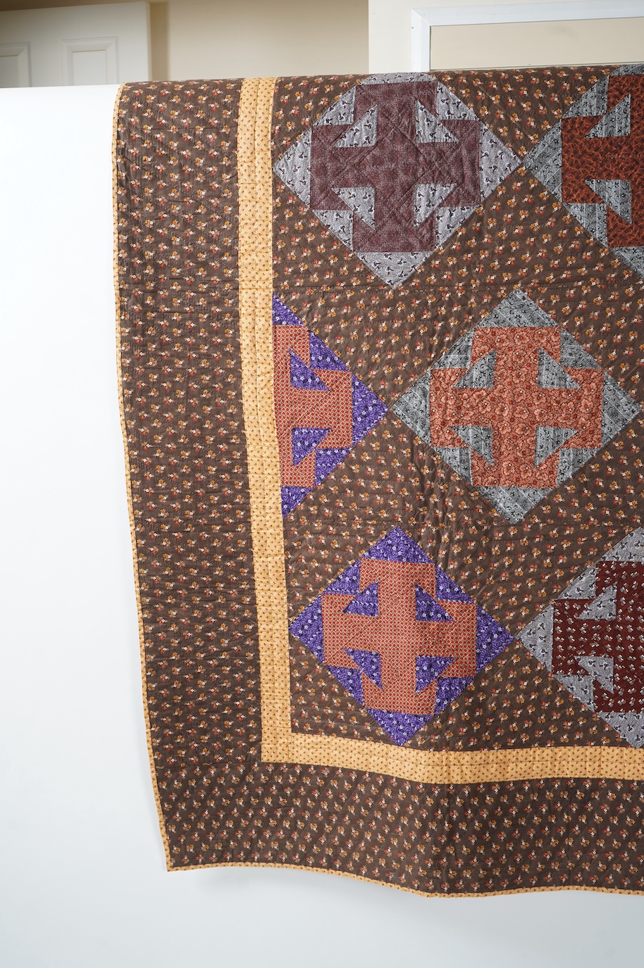 An American Virginian quilt, 1860-1870 (circa American Civil War). Known as a ‘T’ block Virginian style pattern, with a hand pieced and hand quilted front trunk, sold as an unused or washed quilt, designed in brown, red,